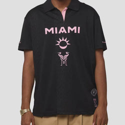 Person wearing a black polo shirt with 'MIAMI' and a sun logo on a white background