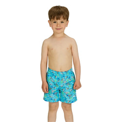 Young boy wearing blue swim trunks with a pattern on a white background
