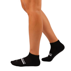 Black socks worn with beige skin-toned tights on a plain background