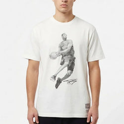 Person wearing a white t-shirt with a graphic design on a plain background
