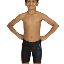 Young boy wearing black swim shorts with blue designs on a white background